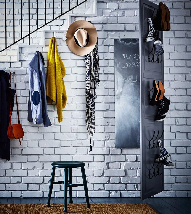 The wall on the side of the stairs with hooks wth coats and hats, and a big mirror as hallway.